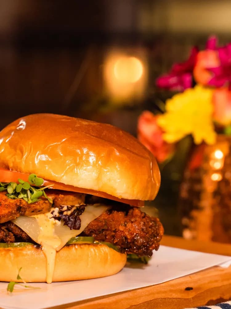 Chef and co-owner Mark McLean's burger at The Burgerly in New Hope, PA, photographed warm on a live-edge wood board.